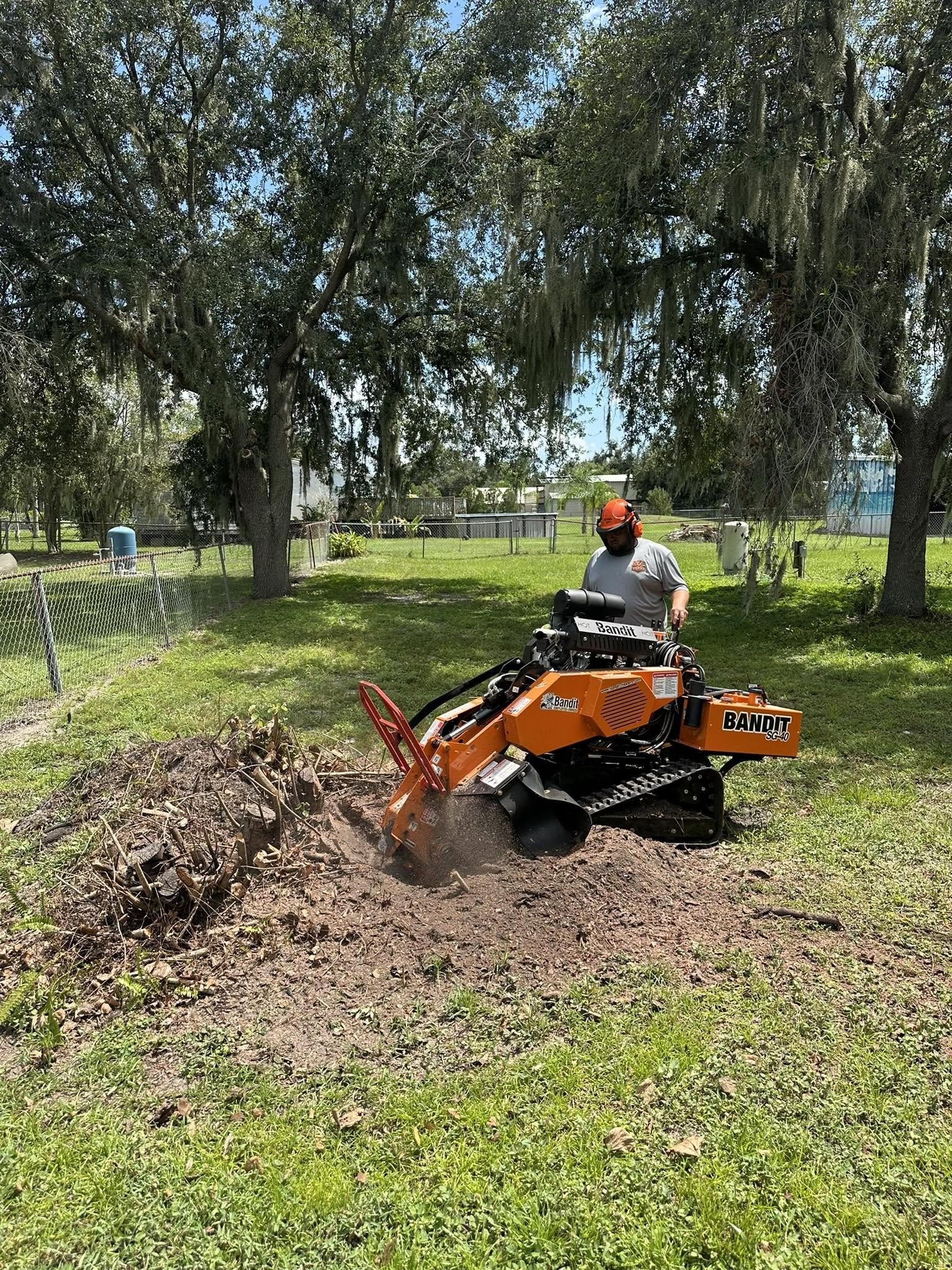 Jud Varn operating a stump grinder on a residential property.