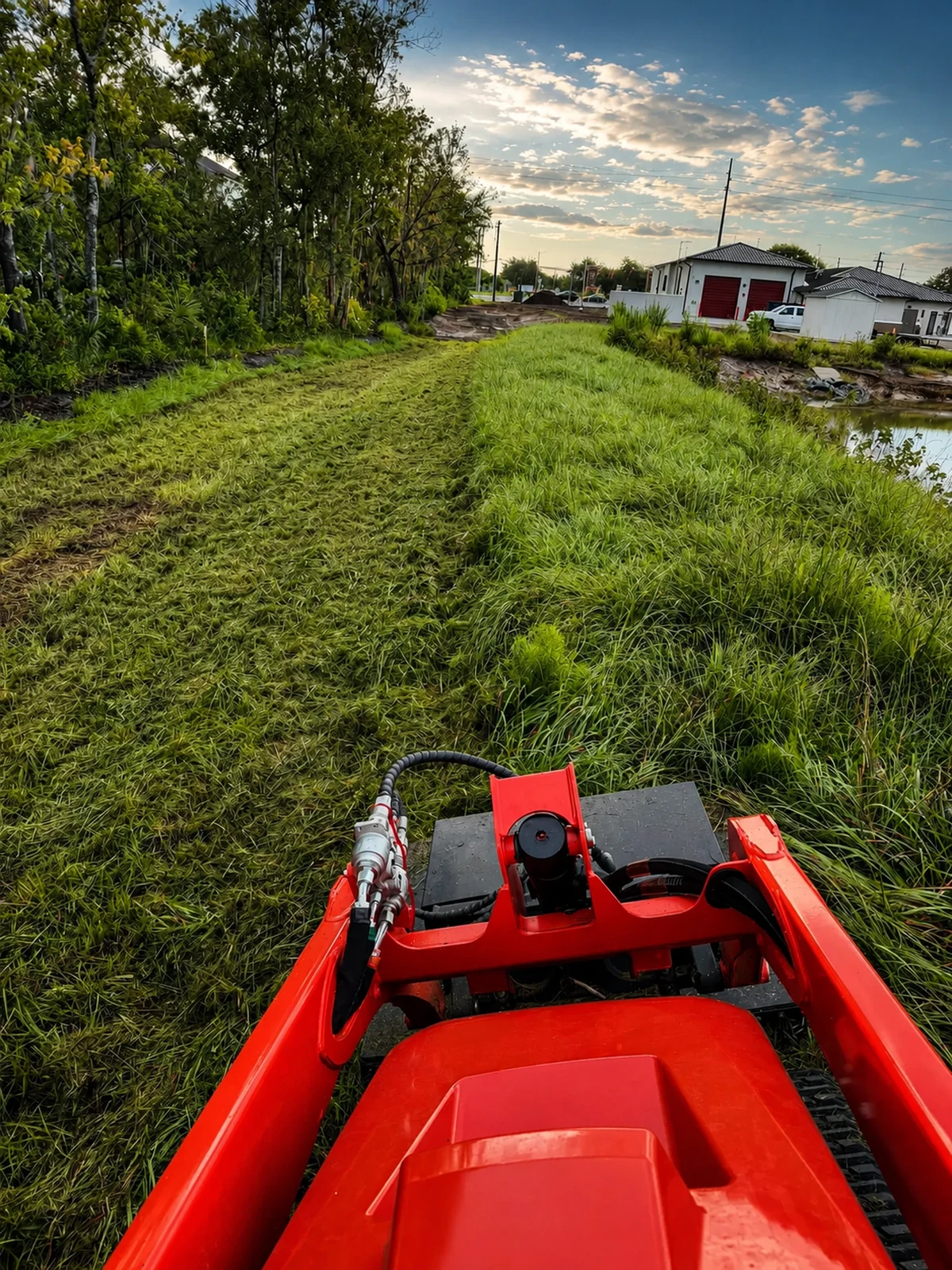 Land-clearing equipment cutting a path through overgrown grass